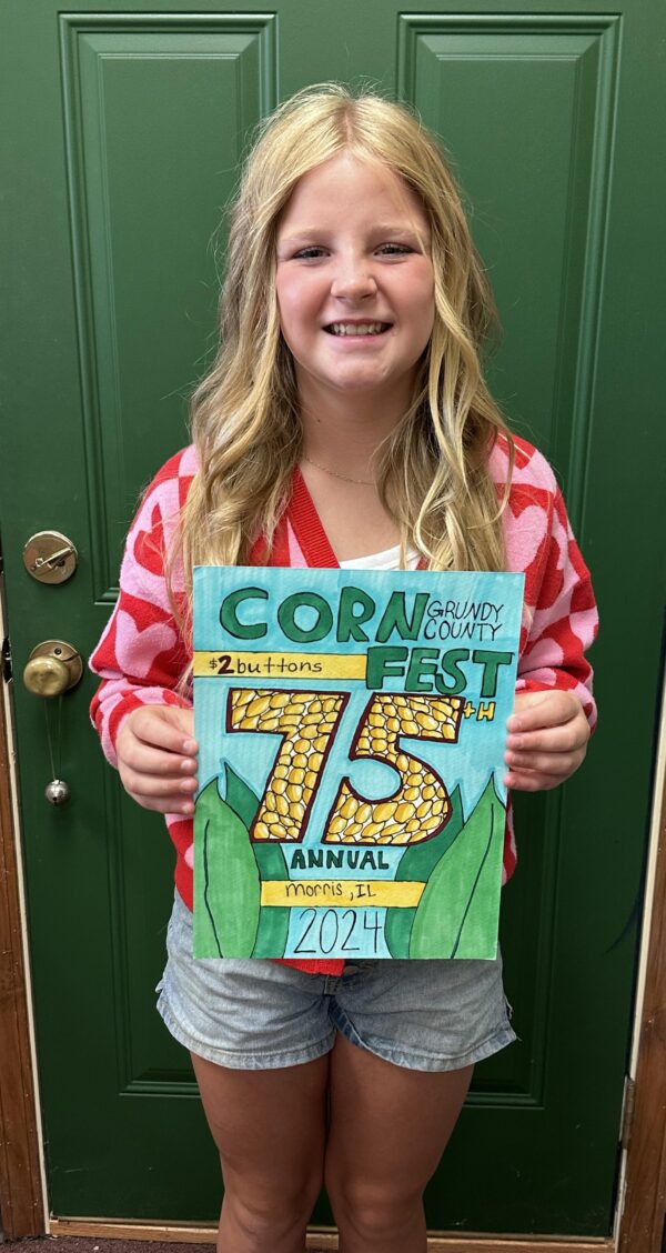 Girl holding Grundy County Corn Fest sign.